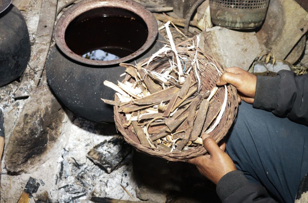 A person holding a basket of bark Bah Brodar Marshillong